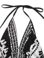Women's printed halter neck maxi dress with tie-back detail from Plush Fashion Hub, featuring a flowing design and vibrant pattern.