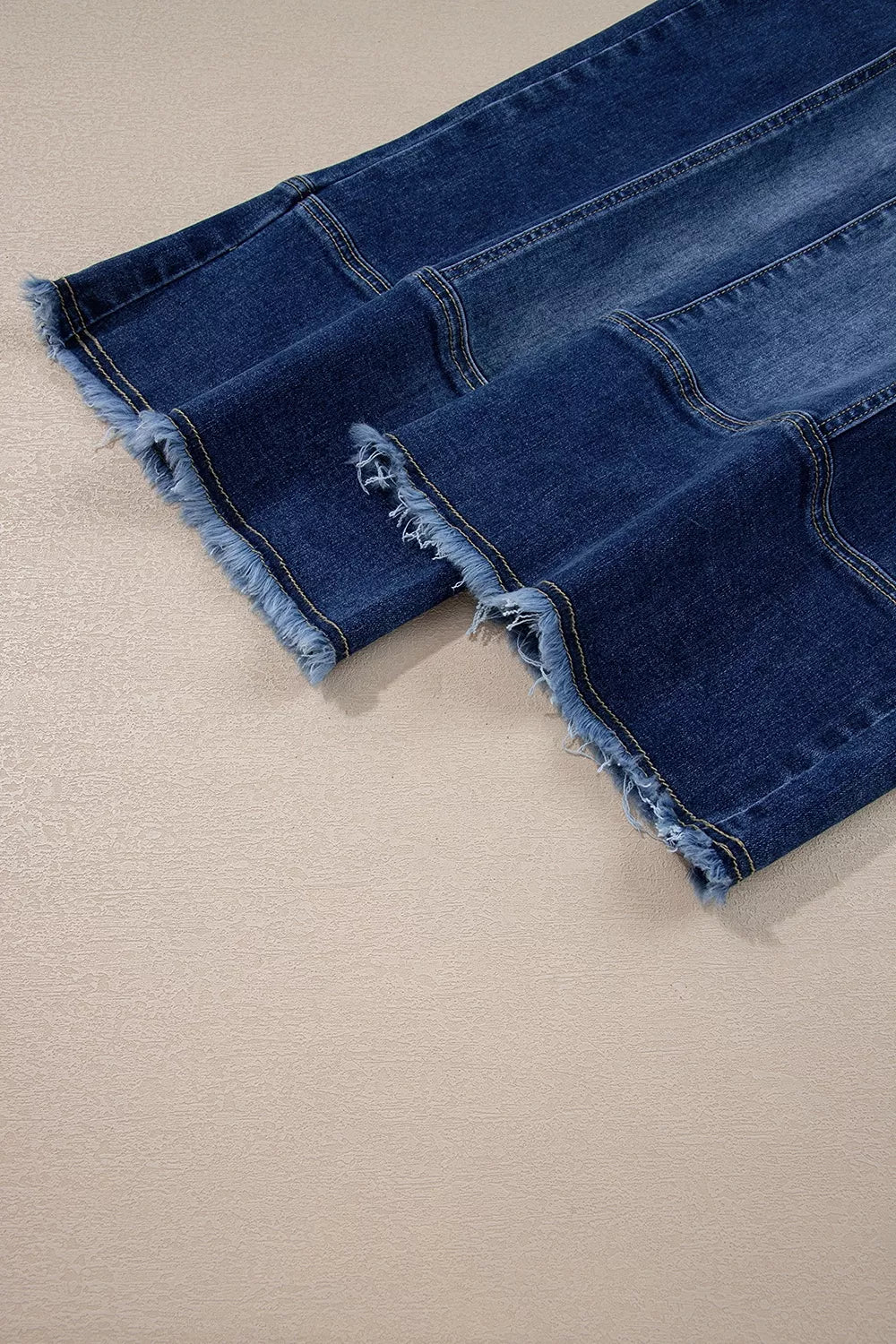 Wide-leg denim pants with drawstring waist, seam details, and raw hem from Plush Fashion Hub, displayed on a hanger.