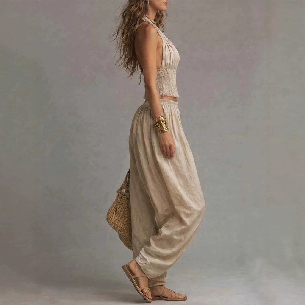 Women's sleeveless backless halter top and wide-leg pants set by FitiqueFit, featuring a stylish, coordinated fashion look.