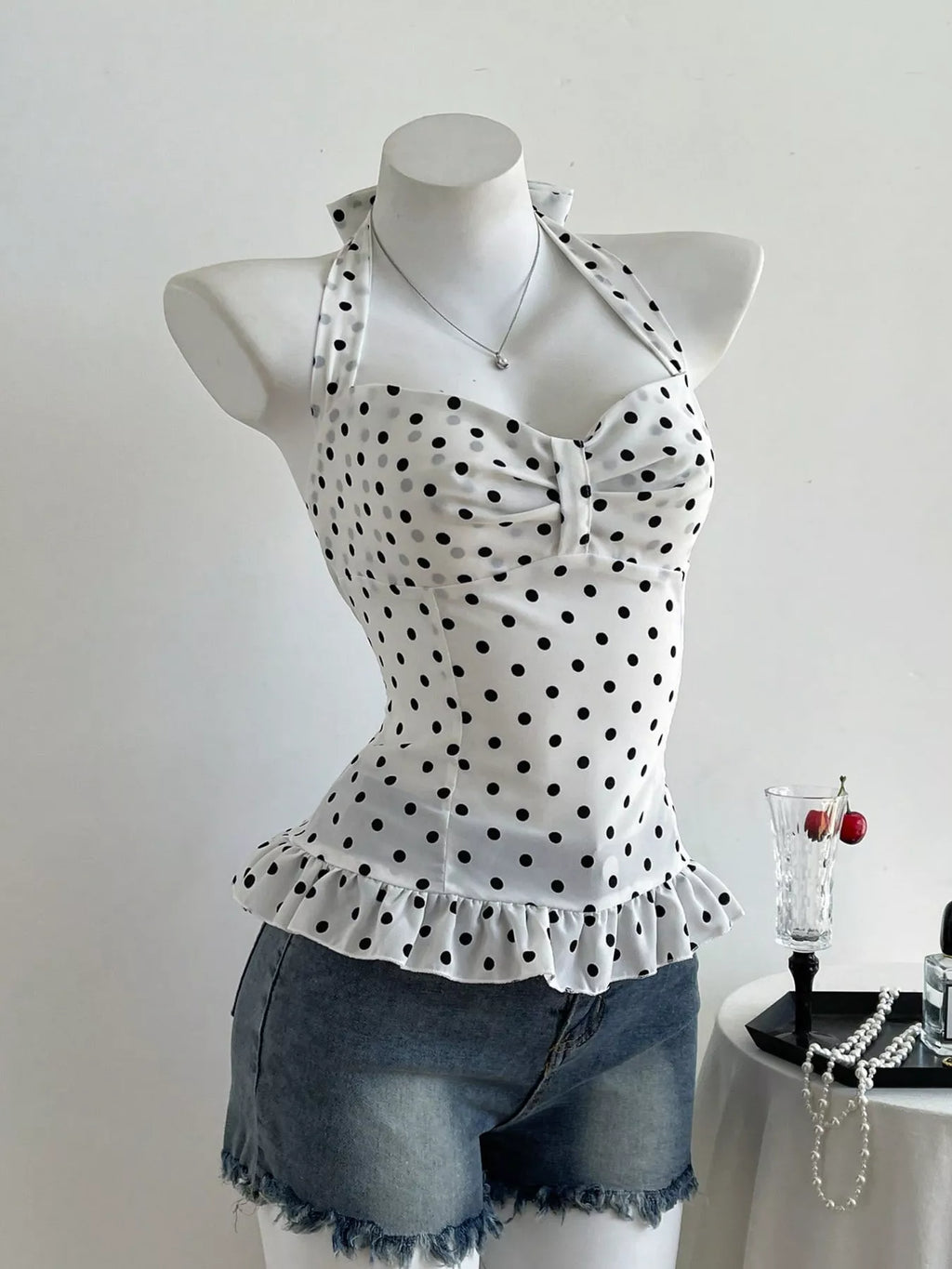 Polka dot halter neck camisole top by Plush Fashion Hub, featuring a stylish polka dot pattern and halter neckline.