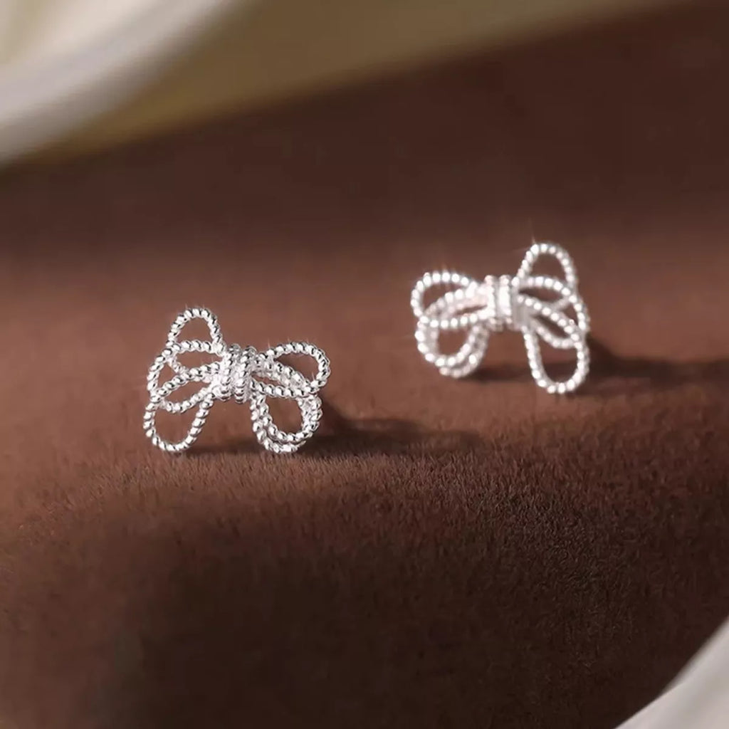 925 sterling silver bow knot stud earrings with a polished finish, showcasing a delicate and elegant jewelry design.