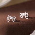 925 sterling silver bow knot stud earrings with a polished finish, showcasing a delicate and elegant jewelry design.
