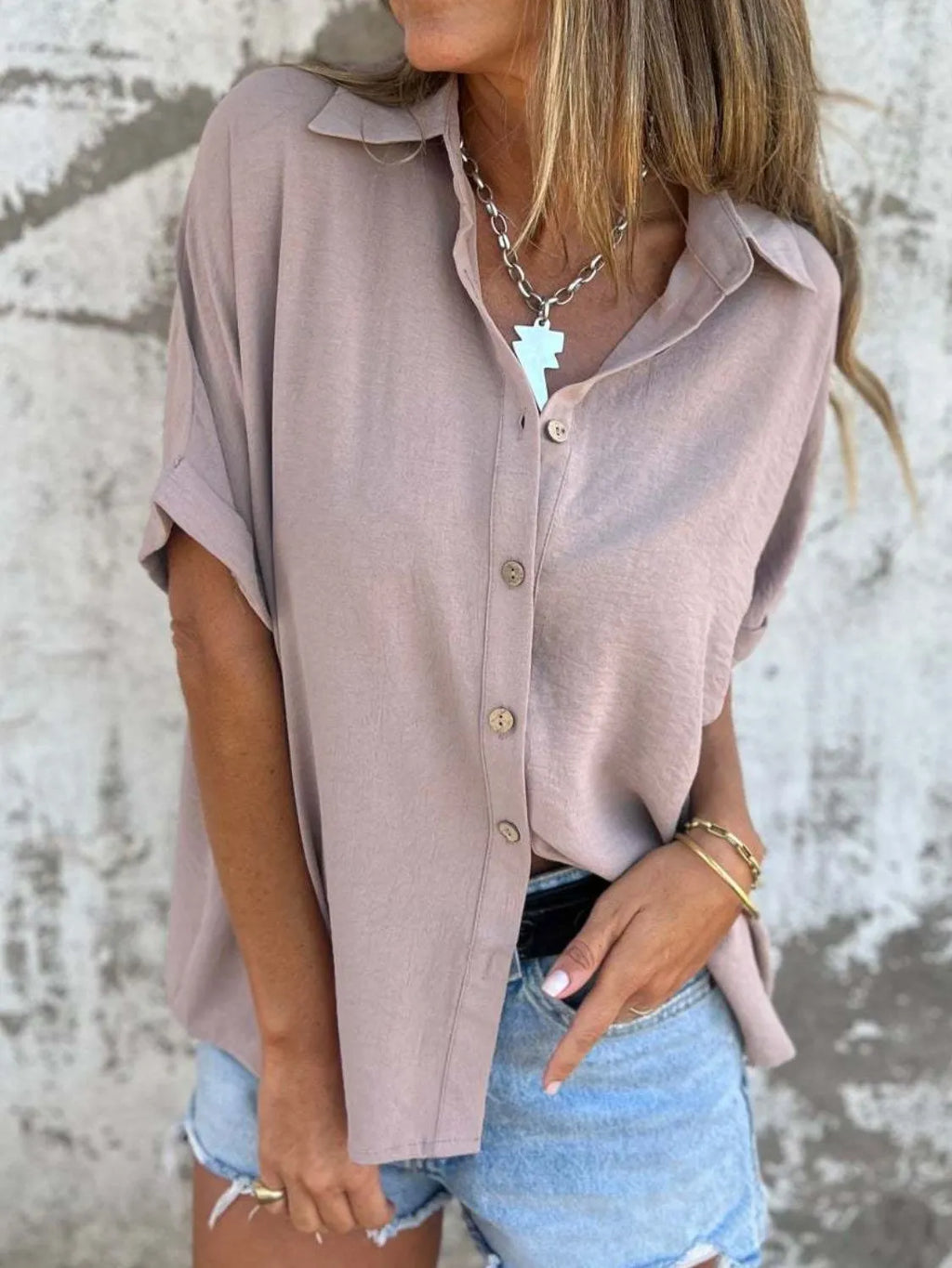 Women's collared half sleeve button-down shirt by Trendsi, showcasing a sophisticated office blouse with a tailored fit and classic design.