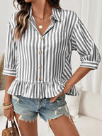 Women's striped button-down blouse with ruffled hem, lightweight viscose fabric, styled with long sleeves and a relaxed fit.