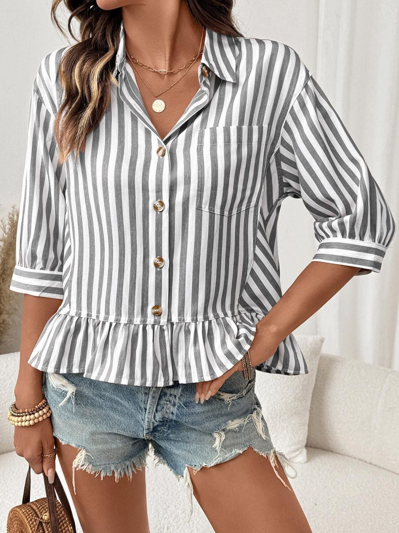 Women's striped button-down blouse with ruffled hem, lightweight viscose fabric, styled with long sleeves and a relaxed fit.