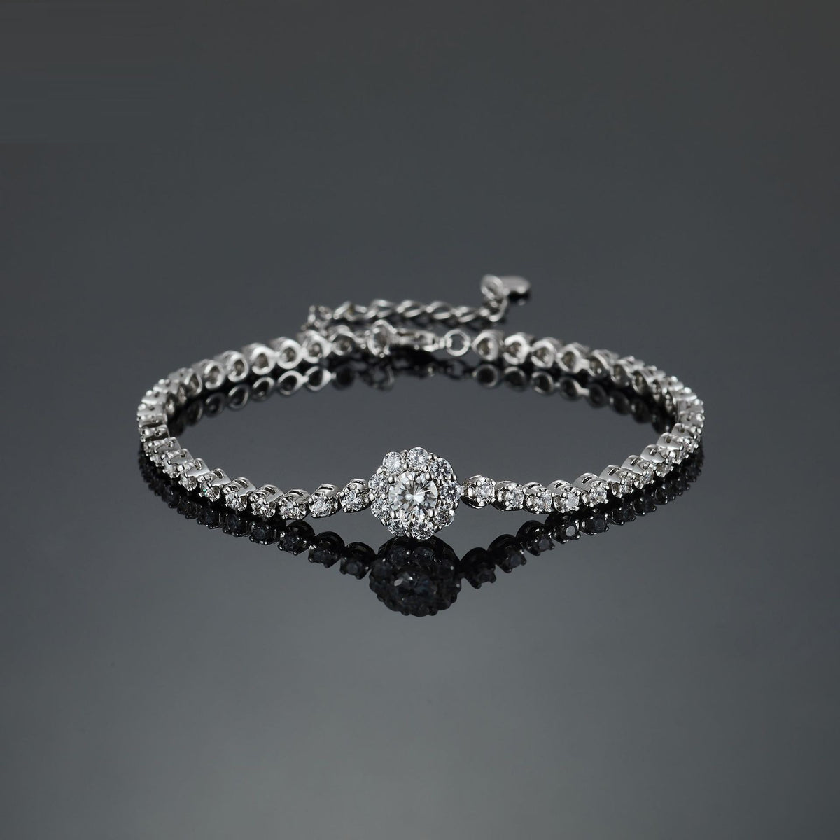 Silver tennis bracelet featuring a central flower-shaped cluster of small round stones.