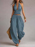 Women's sleeveless backless halter top and wide-leg pants set by FitiqueFit, shown in a stylish, coordinated fashion ensemble.