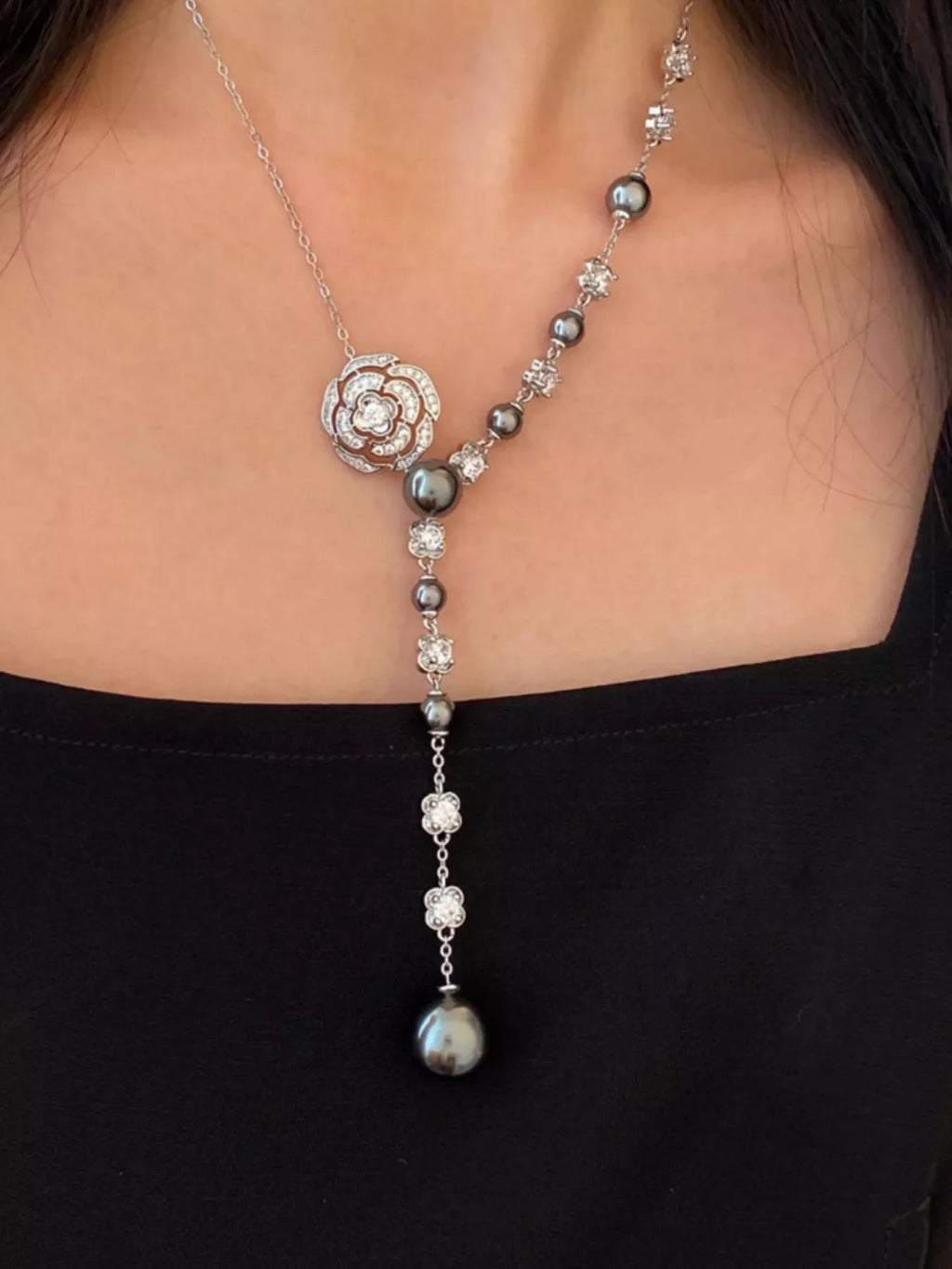 Pearl flower Y-necklace by Shopimist featuring a delicate chain with pearl flower pendant on a white background.