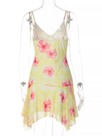Sheer floral print sleeveless asymmetrical mini dress by Shopimist, featuring a flowy design and vibrant flower patterns.