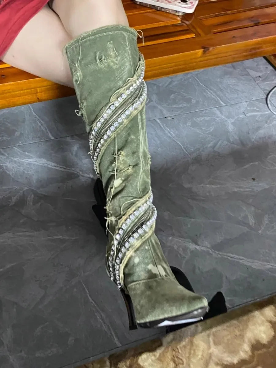 Olive green distressed denim knee-high boot with rhinestones wrapped around the shaft and heel.