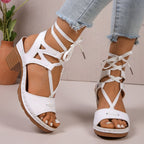 Women's chic lace-up block heel sandals with strappy design and mid-height heel, stylishly displayed from the side.