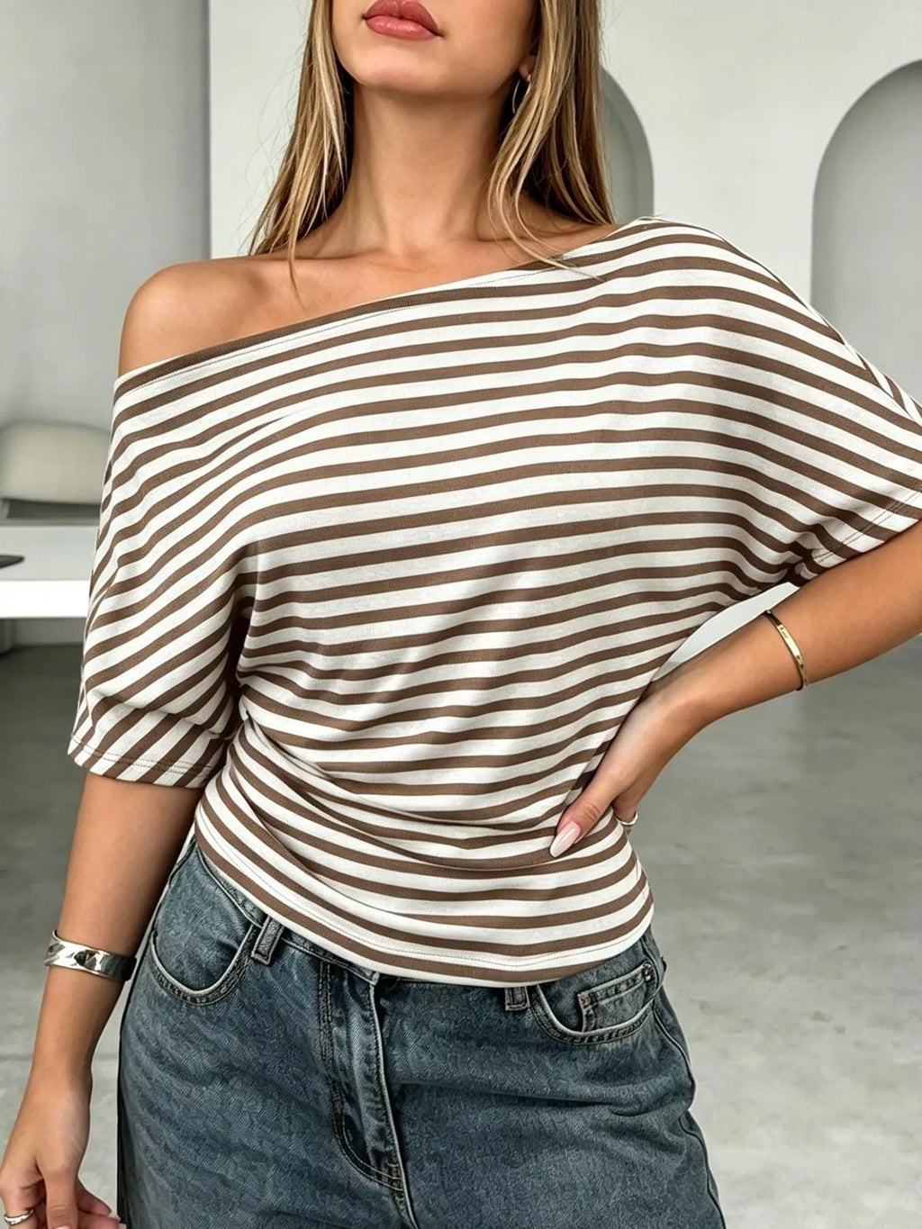 Stripe-patterned one shoulder dolman sleeve T-shirt by Trendsi featuring a relaxed fit and casual style.