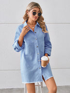 VYSN Raw Hem Button Up Denim Dress hanging on a clothing rack, showcasing its casual style and raw hem detail.