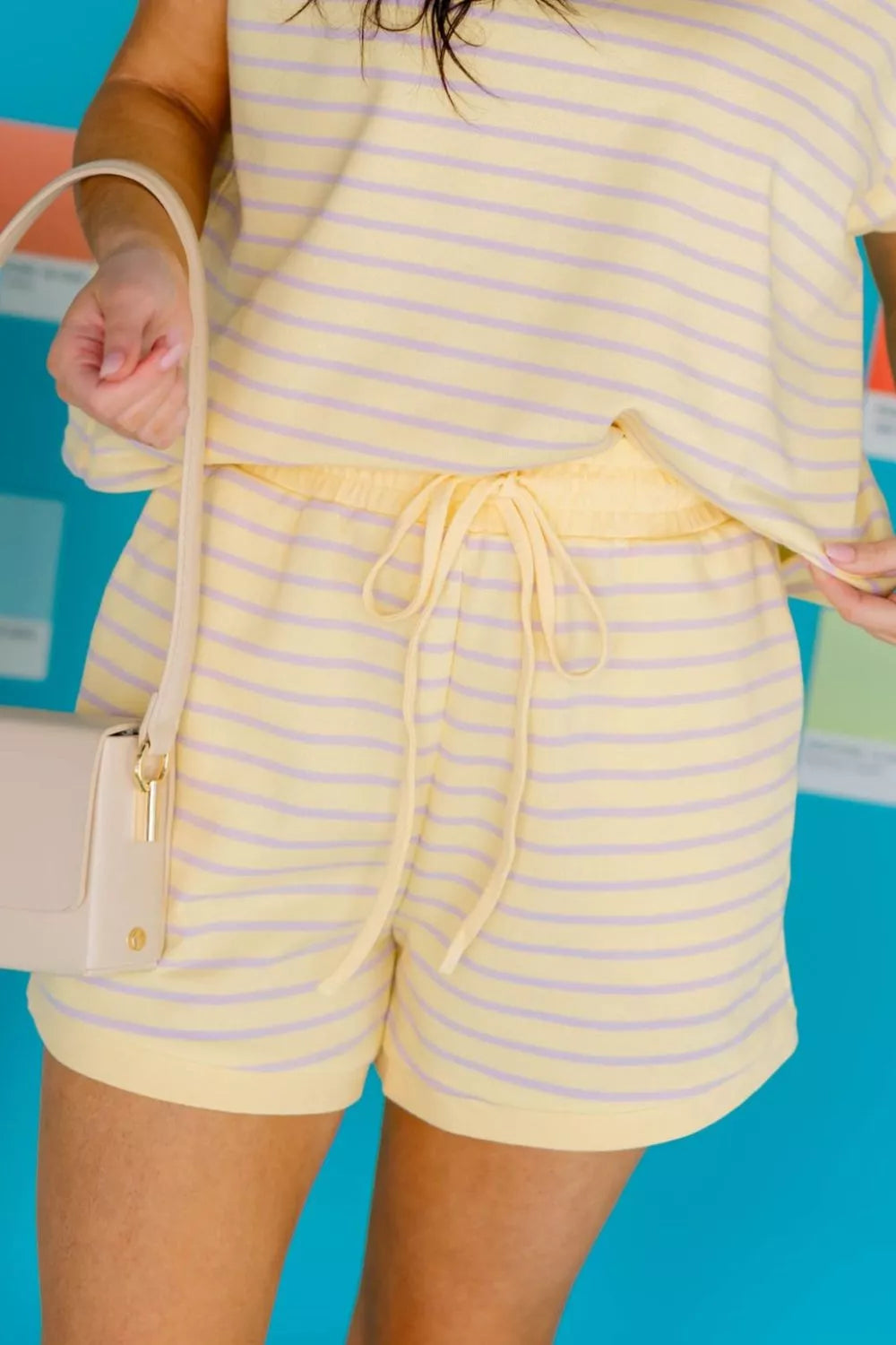 Pair of striped relaxed fit drawstring shorts for women from Trendsi, shown in a casual outfit with rings and accessories.