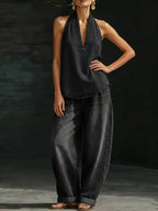 Women's plus size halter neck top and wide-leg pants two-piece set by Trendsi, featuring a stylish dress design with bold fabric.