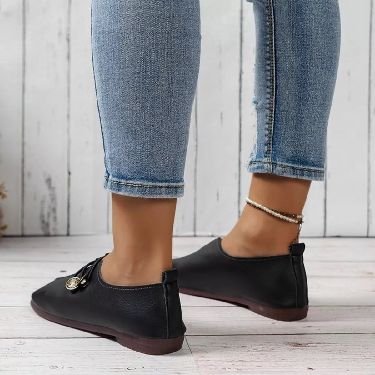 Women's casual slip-on shoes with button details, Trendsi brand, featuring a comfortable slip-on design with stylish accents.