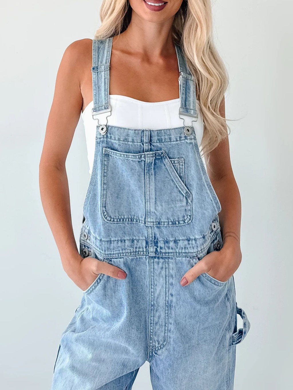 Women's relaxed fit wide strap denim overalls by Trendsi, showing casual jumpsuit with adjustable straps and front pockets.