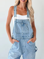 Women's relaxed fit wide strap denim overalls by Trendsi, showing casual jumpsuit with adjustable straps and front pockets.