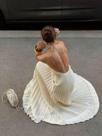 Elegant black halter neck maxi dress with pleated backless design, ideal for formal events by Trendsi.