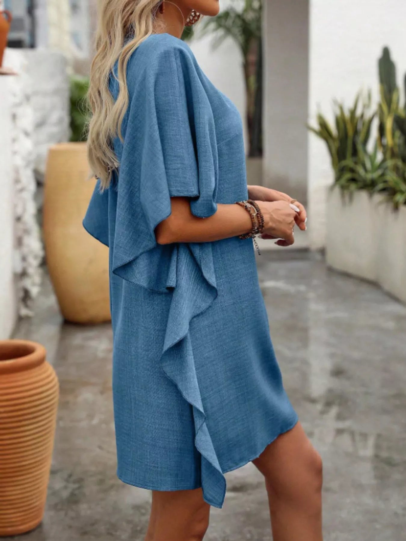 Women's flowy V-neck mini dress with ruffled sleeves, casual style by Trendsi, featuring a relaxed fit and lightweight fabric.