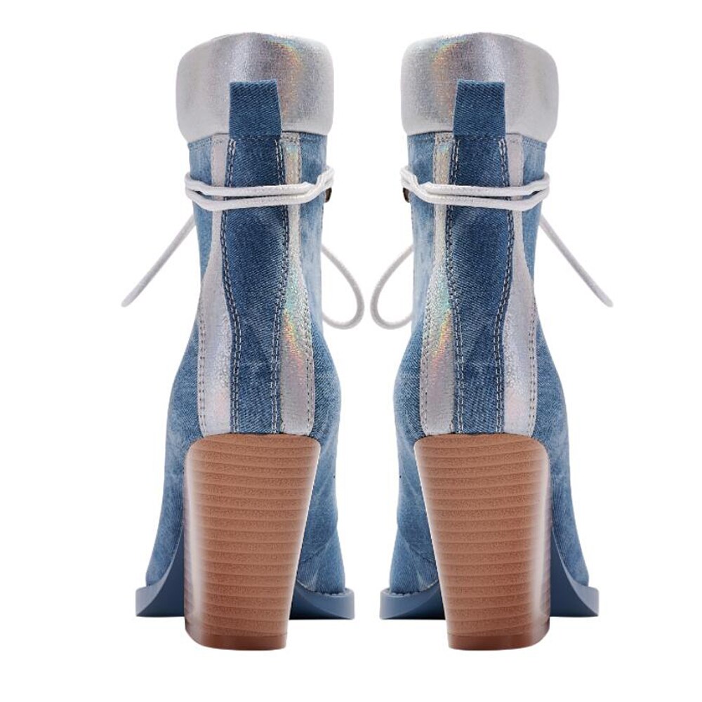 Back view of blue denim lace-up ankle boots with silver metallic trim and chunky brown heels.