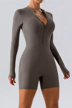 Trendsi half zip long sleeve active romper showing a fitted athletic one-piece with a high collar and sleek fabric.
