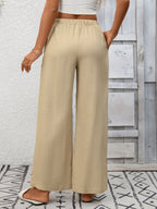 Women's high-waisted wide leg drawstring pants made of soft breathable viscose, shown in a relaxed fit and flowing fabric.