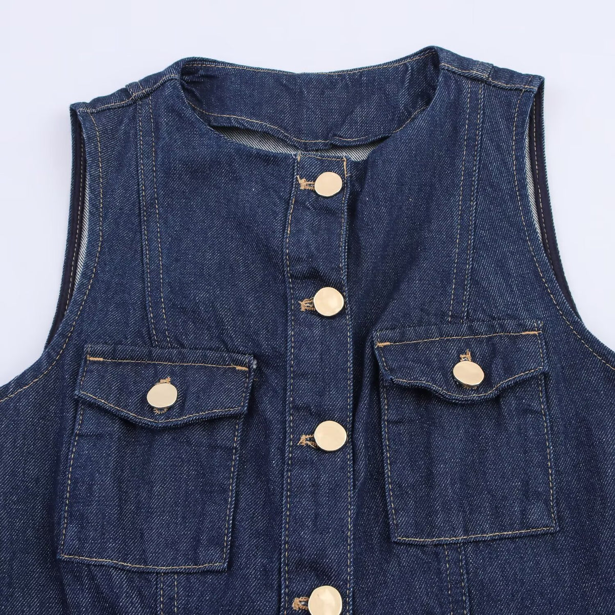 Dark blue denim vest with round neck, front buttons, and two buttoned flap pockets.