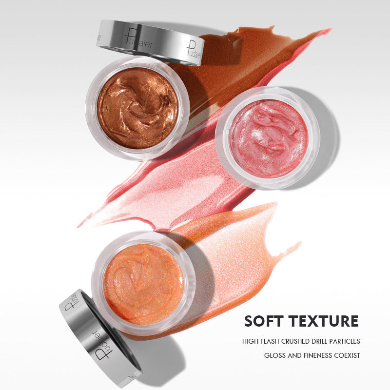 Three glass jars of shimmering lip gloss in copper, pink, and peach, each with swatches and silver lids.