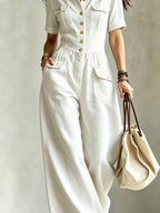 Plus size denim wide-leg jumpsuit with chest pockets, trendy full-size jumpsuit from Trendsi, featuring a relaxed fit and stylish design.