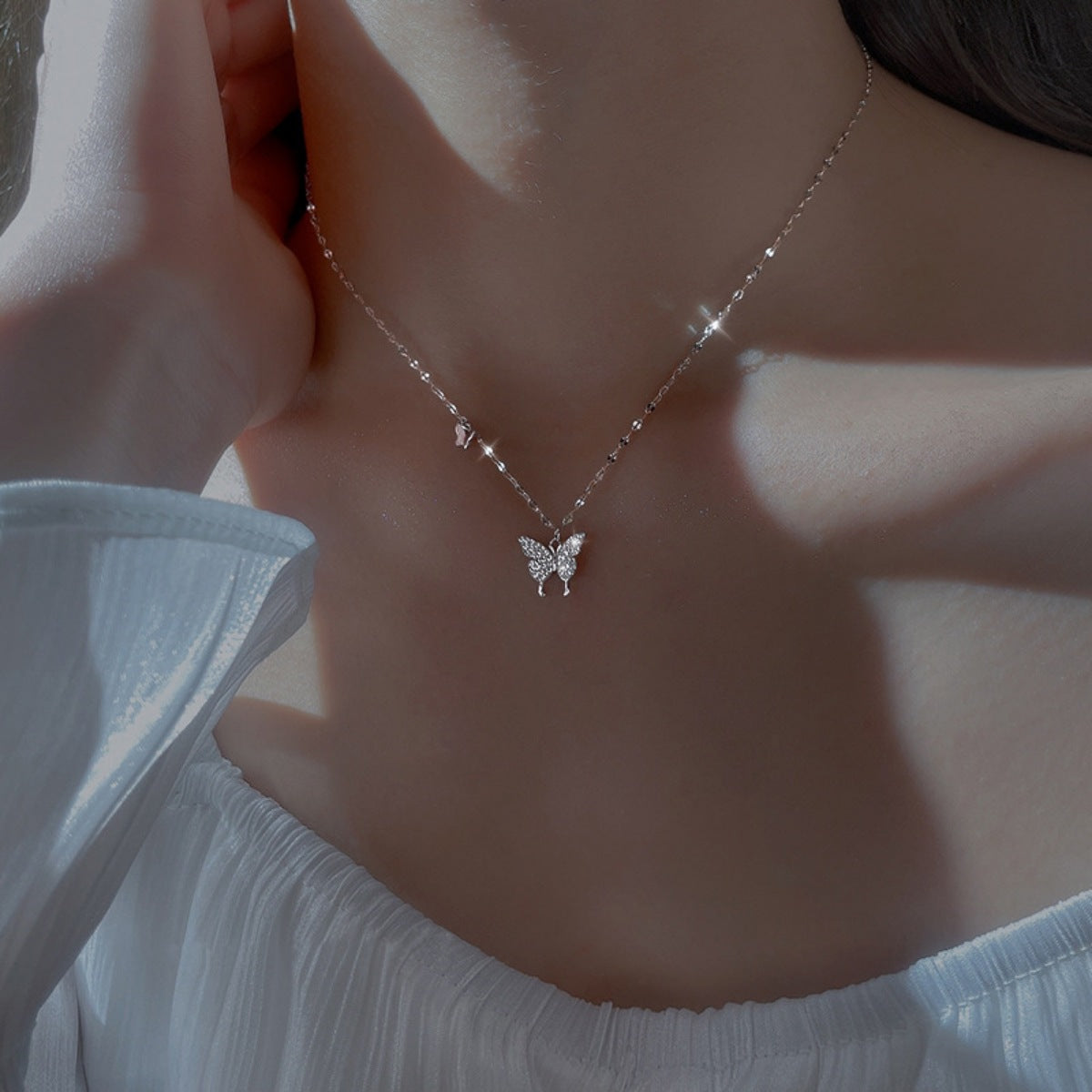 Sterling silver zircon butterfly necklace with delicate pendant, showcasing sparkling stones and fine chain detail.