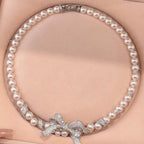 Pearl necklace with bow pendant from Shopimist featuring white pearls and a delicate bow charm on a silver chain.