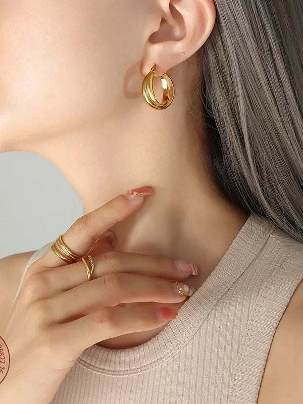 18K gold-plated titanium steel huggie earrings with a sleek, minimalist design, shown on a white background.