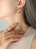 18K gold-plated titanium steel huggie earrings with a sleek, minimalist design, shown on a white background.