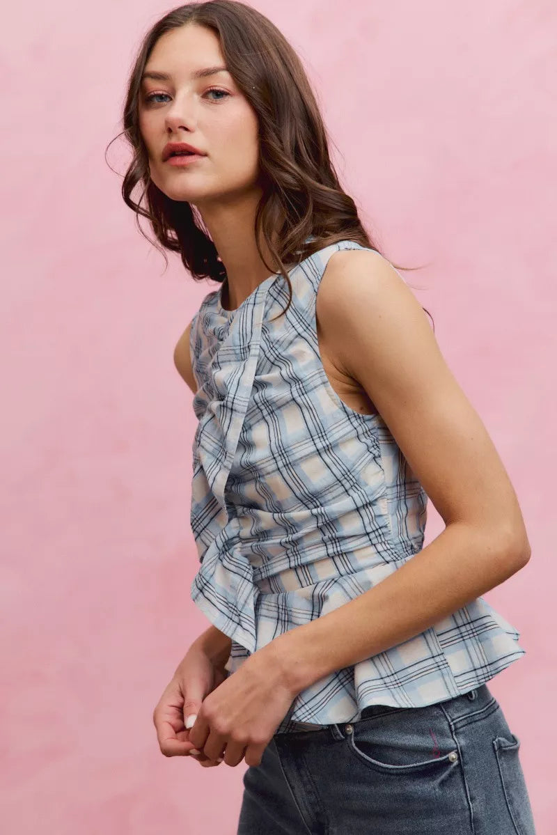 Plaid sleeveless ruffle peplum top from Plush Fashion Hub featuring a stylish design and feminine ruffle details.
