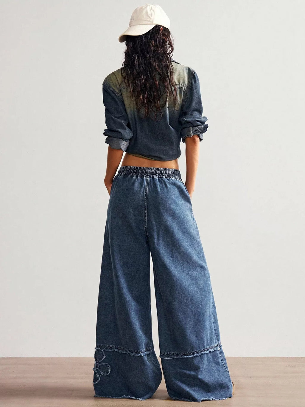 Wide leg jeans with floral appliques from Shopimist, featuring a relaxed fit and decorative floral details on light denim.