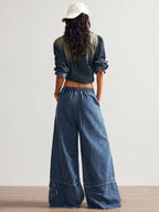 Wide leg jeans with floral appliques from Shopimist, featuring a relaxed fit and decorative floral details on light denim.