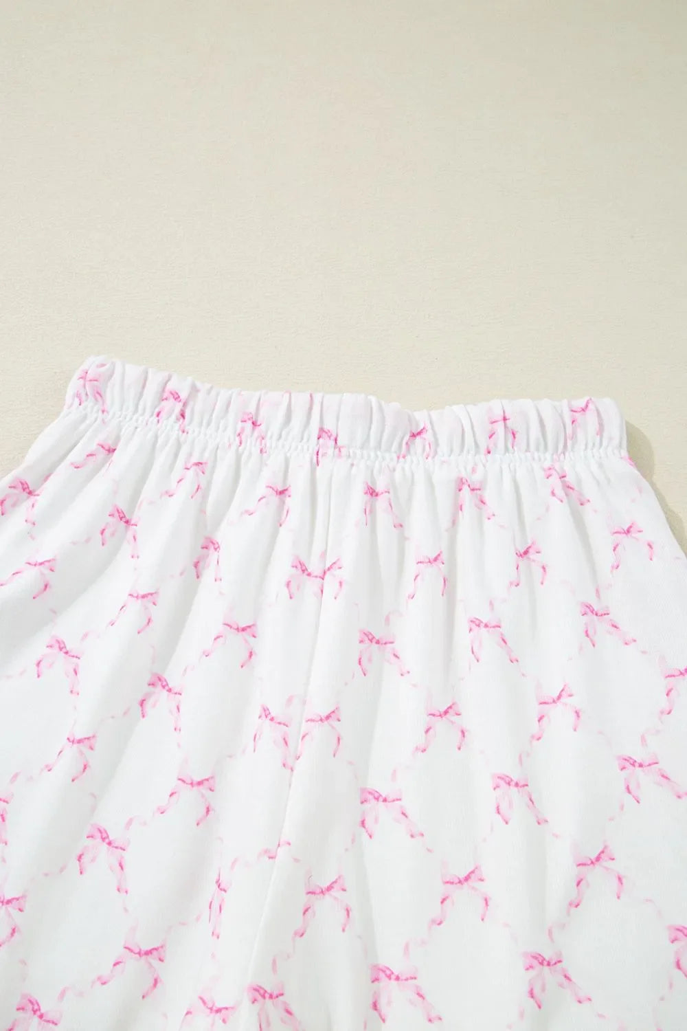 Simply Love bow print lettuce trim round neck top and shorts lounge set, featuring a playful bow pattern and comfortable fit.