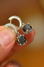 Sterling silver drop earrings with 2 carat moissanite gemstones, elegant jewelry accessory with sparkling stone details.