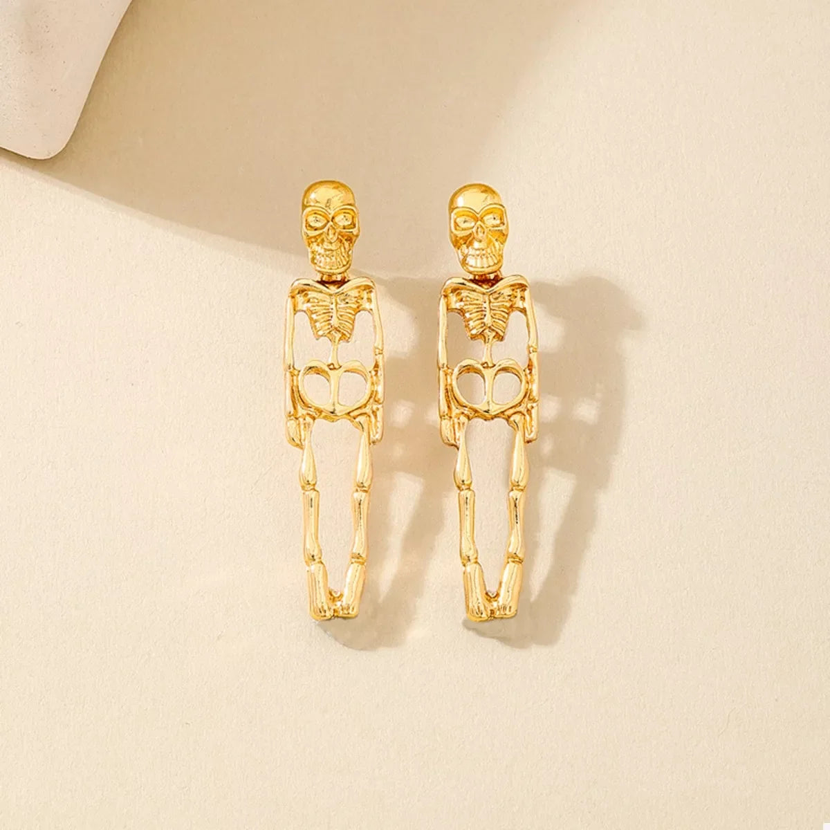 Gold-plated skeleton earrings with Halloween-themed design from Shopimist, featuring intricate skeletal detailing on dangling earrings.