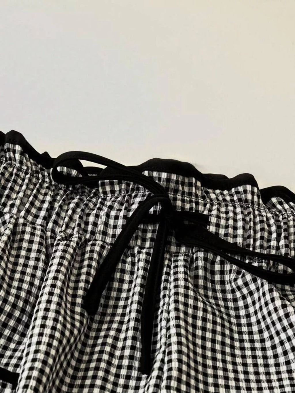 Women's high-waisted gingham wide-leg pants with pockets by Trendsi, featuring a stylish checkered pattern and flowy fit.