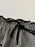Women's high-waisted gingham wide-leg pants with pockets by Trendsi, featuring a stylish checkered pattern and flowy fit.