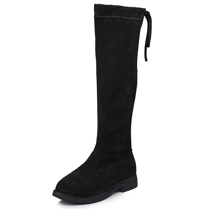 Black suede over-the-knee flat boot with a round toe and back tie closure.