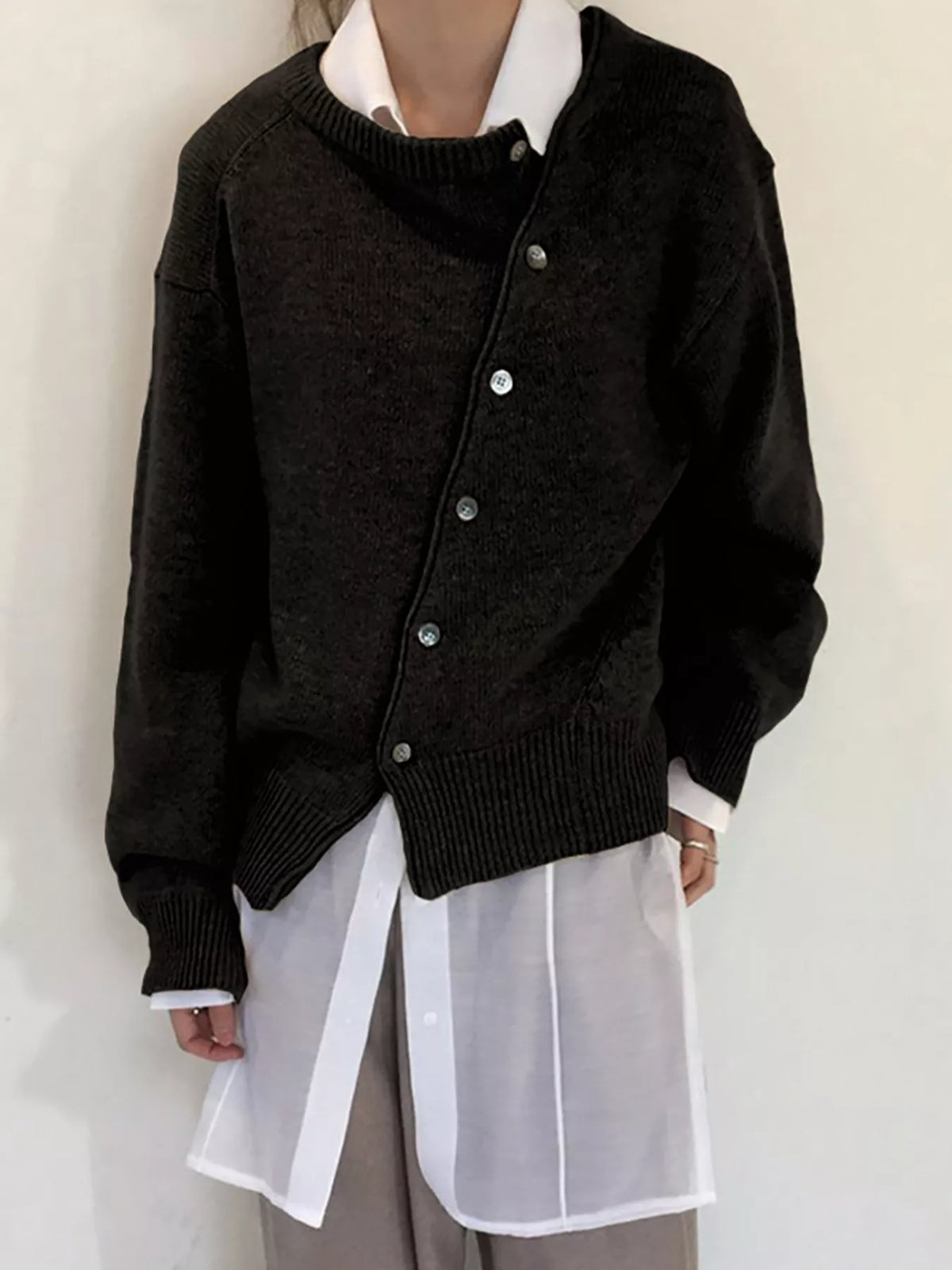 Asymmetric button-down sweater by Trendsi featuring a stylish design, soft knit fabric, and unique front button details.