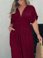 Plus size maxi dress with slit V-neck and smocked waist, trendy full-length dress by Trendsi featuring flowy fabric and elegant style.