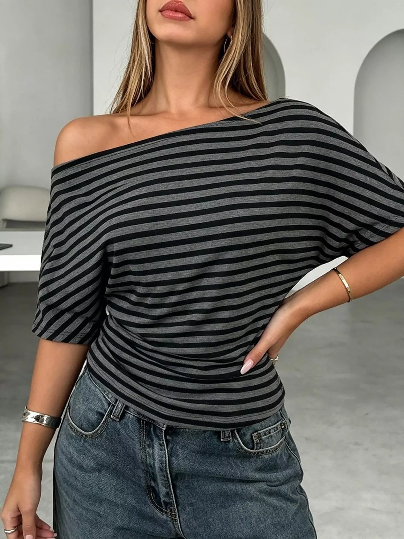 Striped one-shoulder dolman sleeve T-shirt by Plush Fashion Hub, featuring a stylish design with relaxed fit and contrasting stripes.