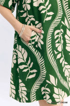 Umgee leafy ogee print mini dress with long sleeves and V-neck, featuring a vibrant floral pattern and flowing fabric.