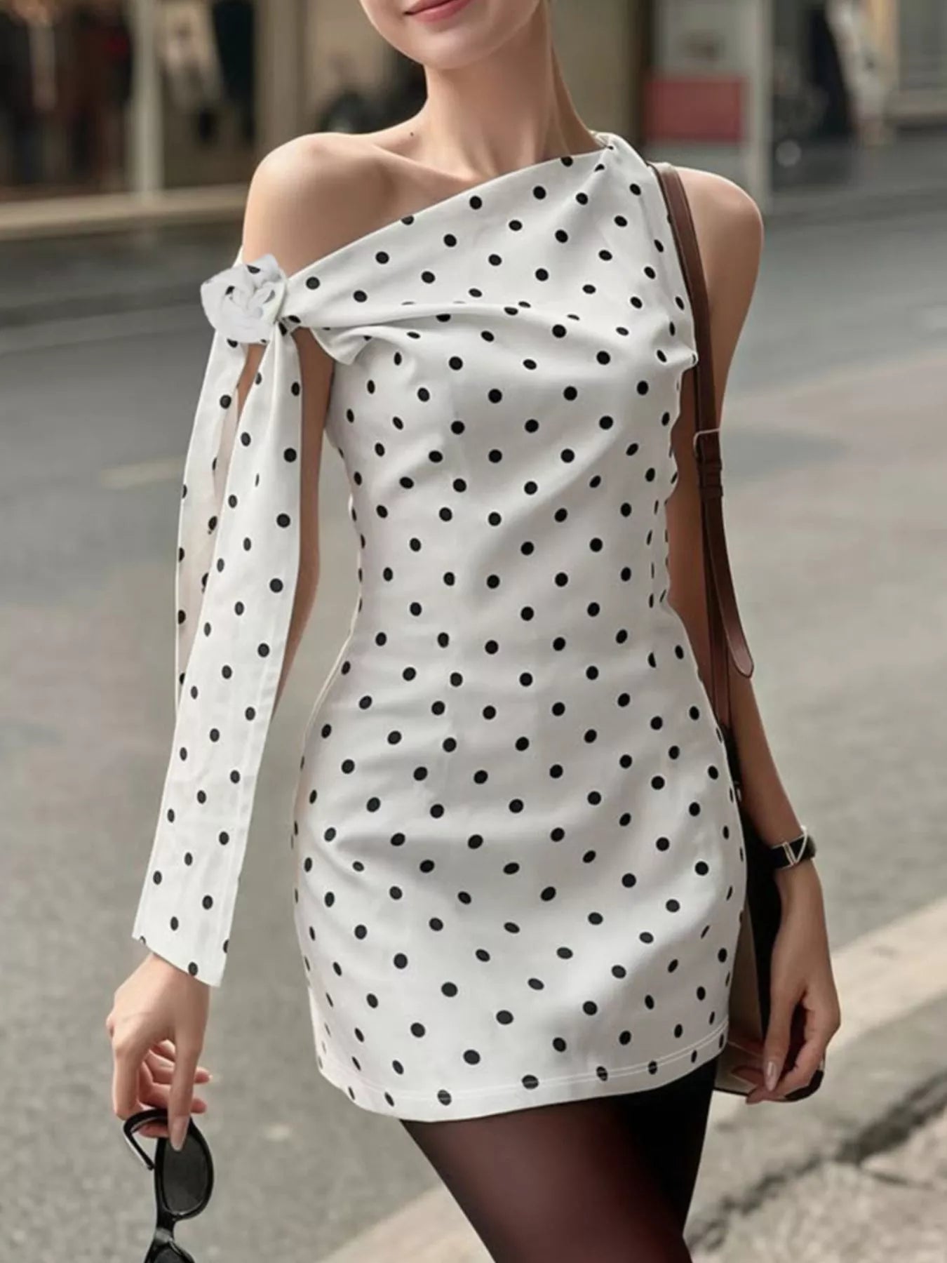 Polka dot sleeveless mini dress with bow accents from Shopimist, featuring a fitted bodice and playful pattern.