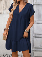 Women's casual V-neck mini dress with ruffle hem and ruched detailing, trendy dress by Trendsi, shown in a stylish fabric.