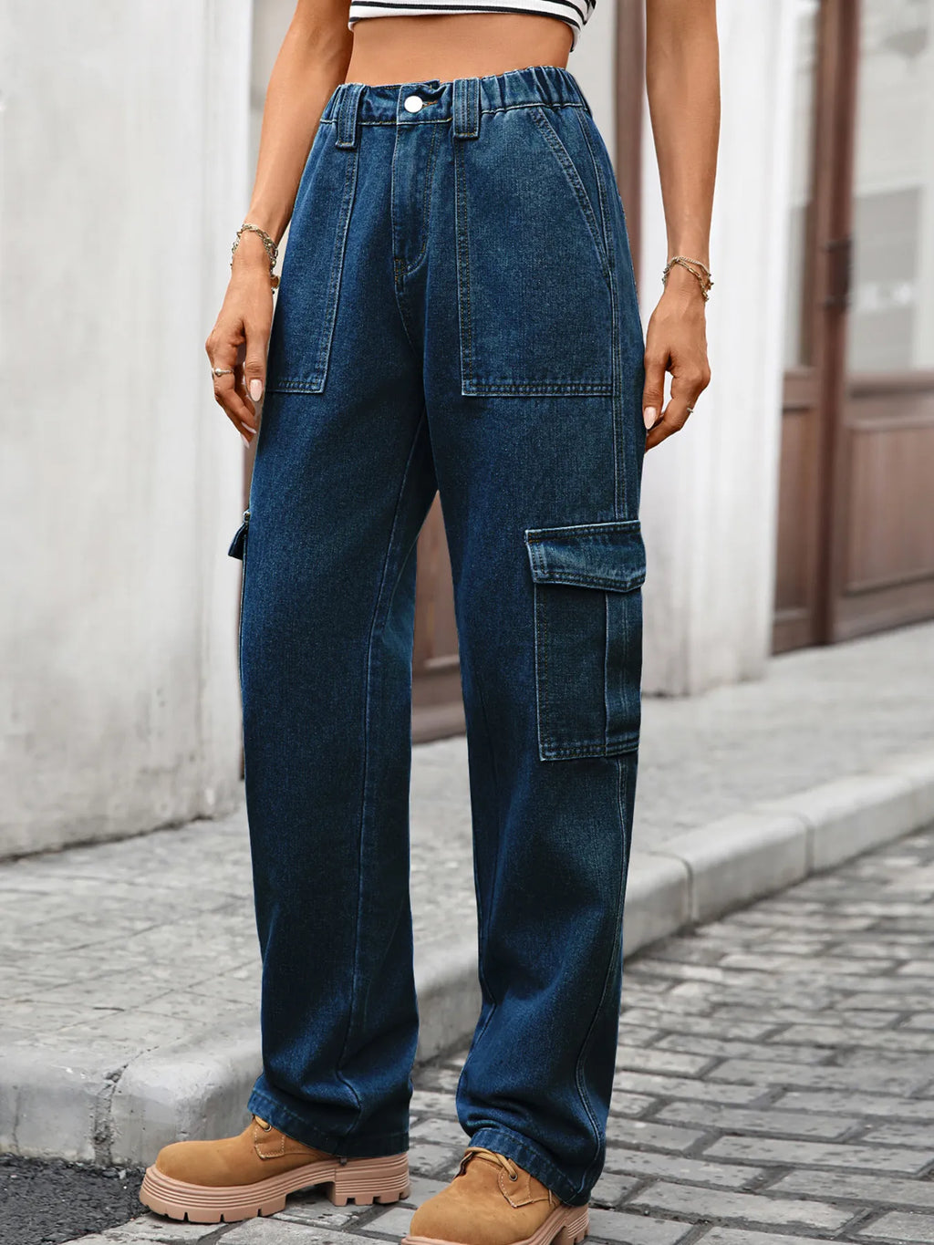 High-waisted cargo denim jeans from Plush Fashion Shop with multiple pockets and a relaxed fit, displayed on a hanger.